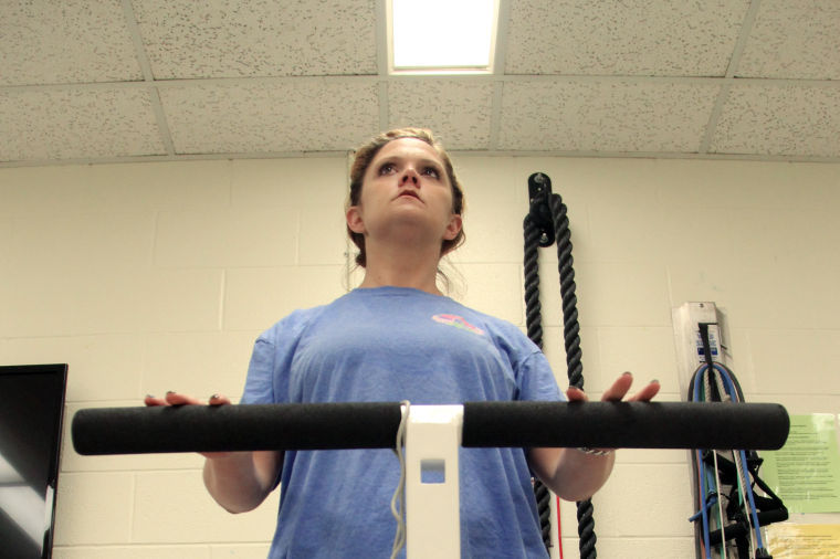Brandi Todd is supported by a standing frame, a device that helps people who rely on wheelchairs the opportunity to stand up. Todd uses the device to improve her standing position and to work out on in Tarleton’s Psycle Lab.