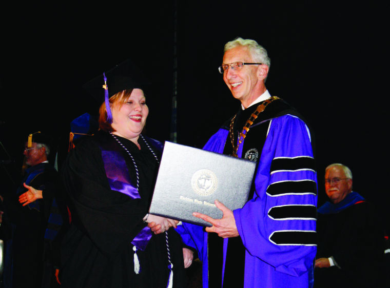 While walking across the stage during the December 2013 graduation, Christina Hannan recieved her empty diploma holder from Tarleton State University President Dr. F. Dominic Dottavio.