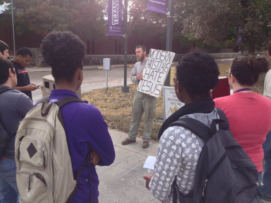An+unnamed+man+sported+controversial+signs+outside+the+Dining+Hall%2C+attracting+a+crowd+of+students.