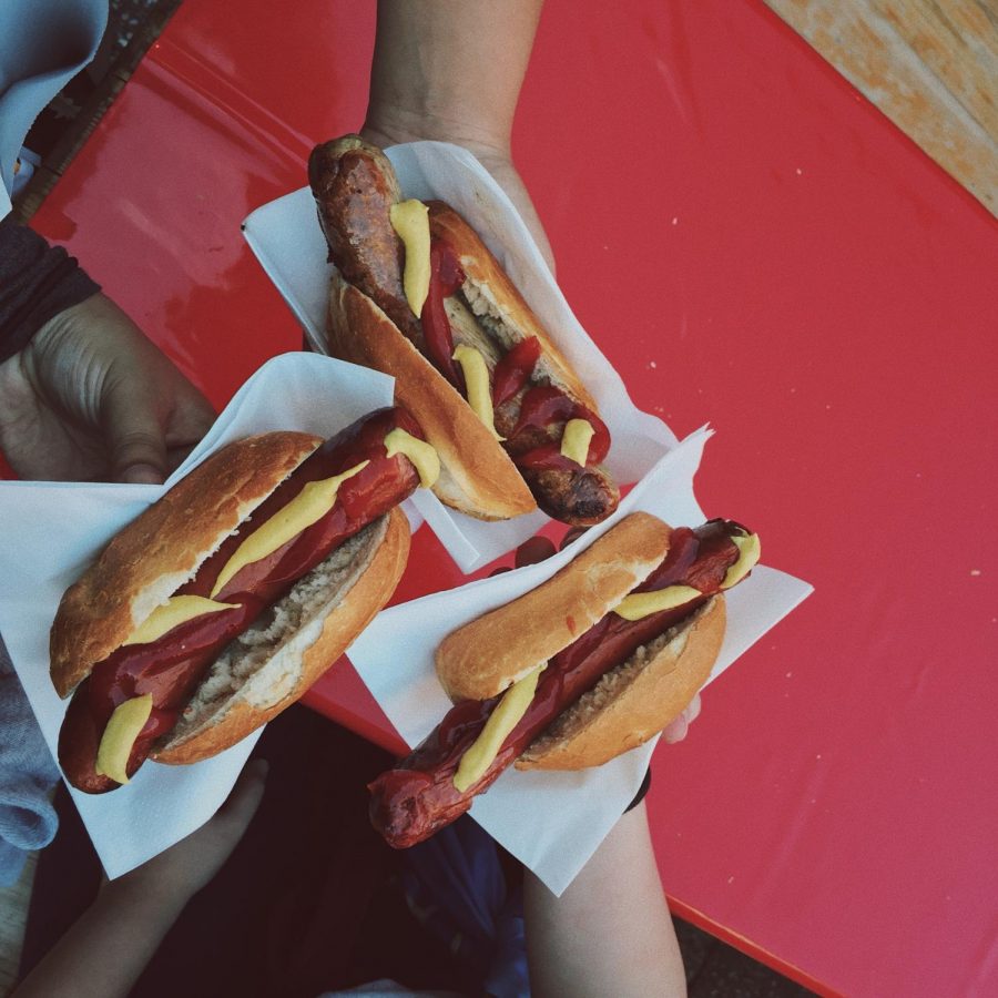 A photo of a group of people holding hot dogs. 