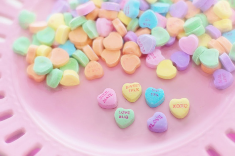 A bowl of candy hearts that give a message on each heart.