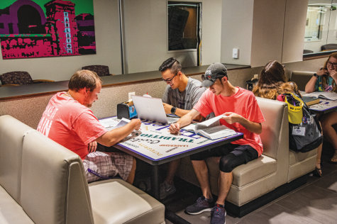 Austin Sikes, Trent Higgins and Elijah Perry Imbong studying on the main floor of the library near Study Grounds.